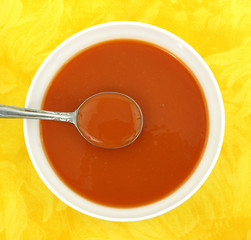 Tomato soup in white bowl with spoon