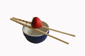 Strawberry and chopsticks isolated on white