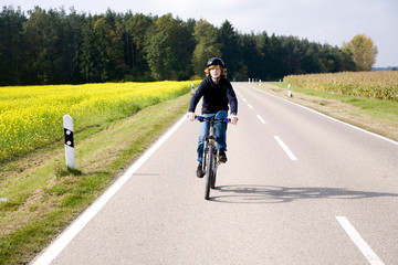 Jugendlicher bei Fahrradtour auf Landstrasse in Bayern