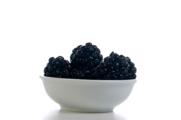 some organice blackberries in a white bowl