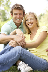 Naklejka premium Portrait Of Young Couple Sitting In Park