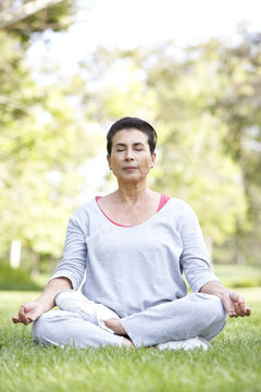 Senior Woman Doing Yoga In Park