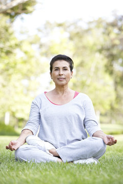 Senior Woman Doing Yoga In Park