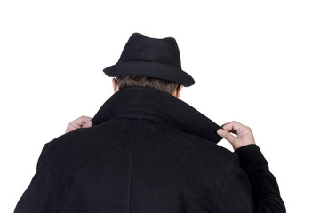 Mysterious man wearing a black coat with a raised collar