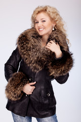 Beautiful smiling woman in a winter jacket with a fur collar