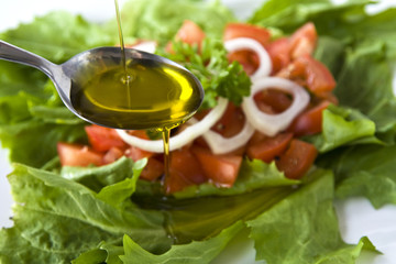 Salat mit Tomaten, Löffel und Öl