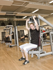 Obraz na płótnie Canvas Young man using an exercise machine