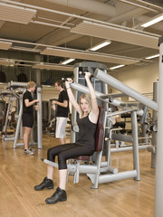 Naklejka na ściany i meble Girl using an exercise machine