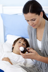 Mother giving her son syrup