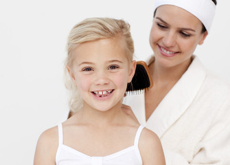 Beautiful mother doing daughter's hair