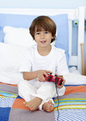 Boy sitting in bed playing videogames