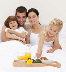 Obraz na płótnie Canvas Happy family having breakfast in bedroom