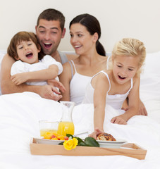 Obraz na płótnie Canvas Family having breakfast in bed in the morning