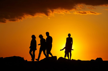 Fototapeta na wymiar Silhouette of people on the beach at sunset