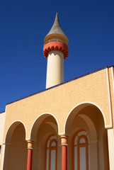 Fototapeta na wymiar Tower and arcades detail on blue sky background