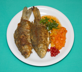 Fried fish in plate on a green background