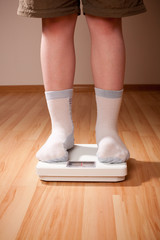 Boy measures weight on floor scales