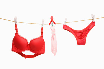 Red underwears, ribbon and condoms hanging on rope