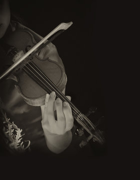 Young artist with play violin on black background
