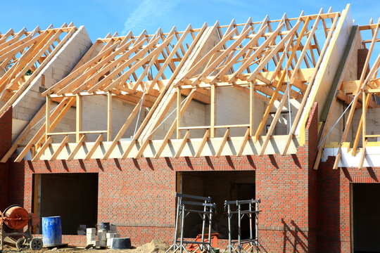 Neubau Reihenhaus Dachbalken Rohbau blauer Himmel