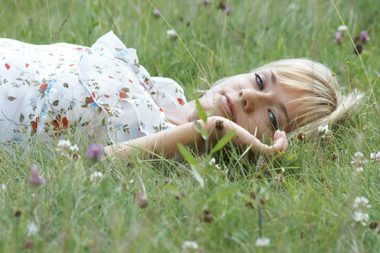 The beautiful girl lies in a grass