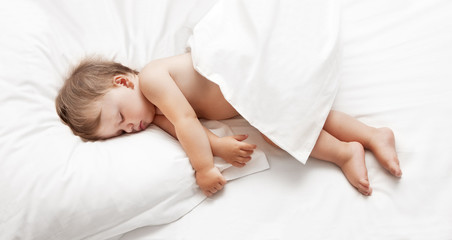 Obraz na płótnie Canvas Baby lying on white sheet