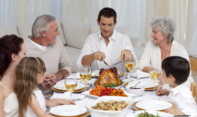 Father serving turkey to his family in a dinner