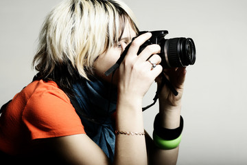 Young beautiful woman taking a photo with a digital camera
