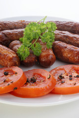 grilled beef sausages and tomato on a plate
