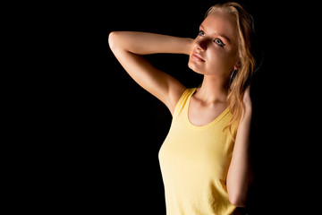 sensual blonde girl with lifted arms isolated on black