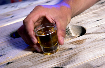 Person holding shot glass.