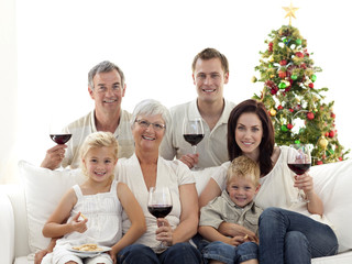 Family drinking wine and eating sweets in Christmas