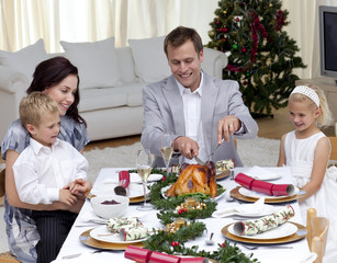 Father cutting a turkey in Christmas dinner