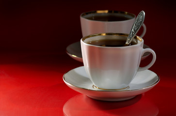 Two cups of coffee on a red-black background
