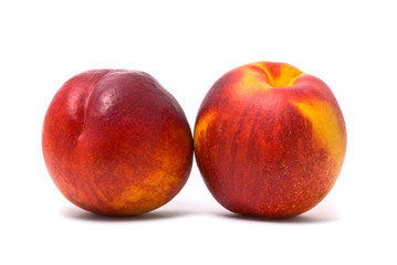 Two juicy nectarines on a white background