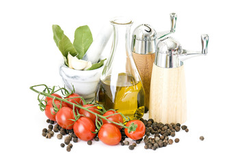 bottle of olive oil and spices and vegetables isolated on white