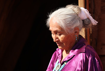 A Navajo Woman Looking Down Outdoors in Bright Sun - obrazy, fototapety, plakaty