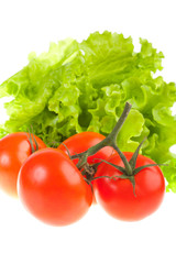 Ripe red tomatoes and green leaves of salad.