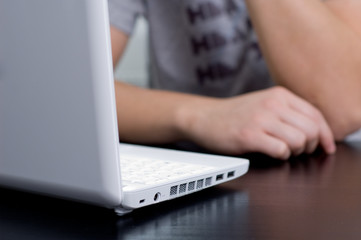 Man in casual clothing thinking in front of his netbook