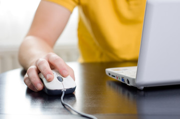 Man in yellow shirt with his right hand on the mouse