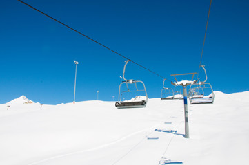 Ski lift chairs on bright winter day