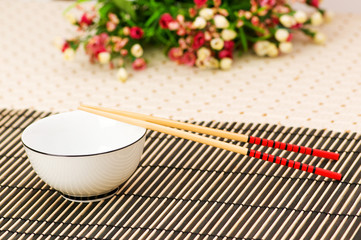 Chopsticks and bowl on the bamboo mat
