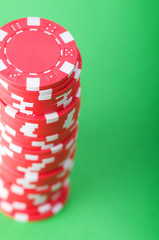 Stack of red casino chips against green background