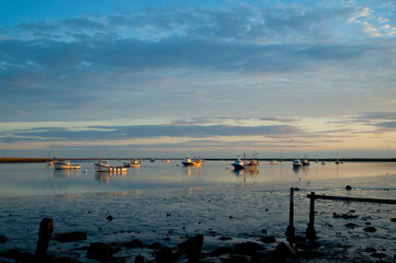 sunset over moored estuary fishing boats