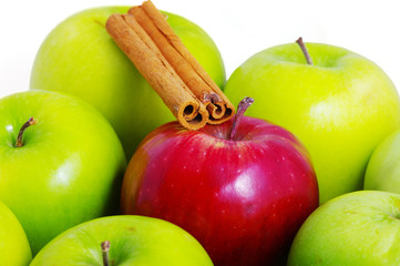 Background of green apples with one red apple and cinnamon stick