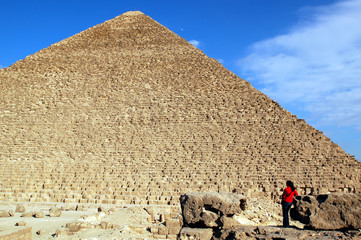 Woman in red in front of world famous Egyptian pyramids
