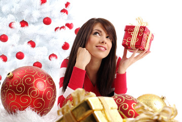 Beautiful girl with gift box next to white christmas tree