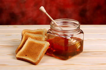 Jar of honey, dipper and toast