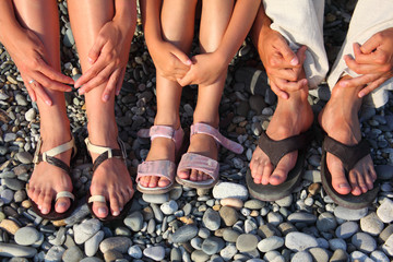 lot of legs and hands on the stones. family with girl