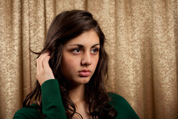 Beautiful young lady on golden curtain background